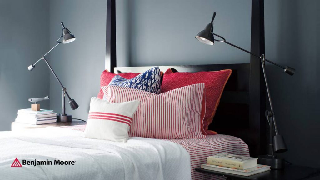 A bed with 2 lamps and red and white pillows against a dark wall near Columbia & Spring Hill, TN